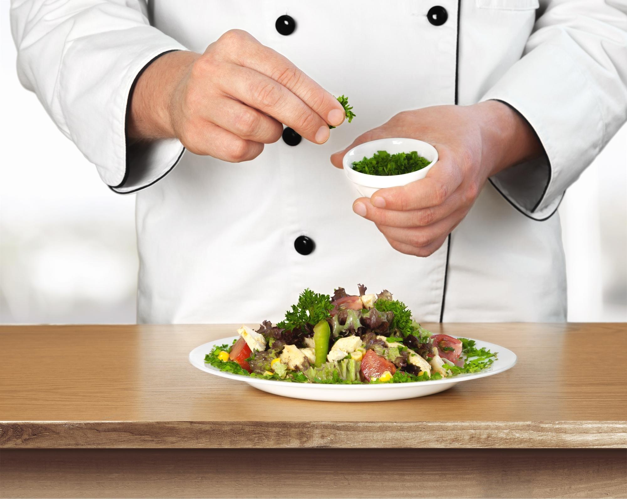 Chef plating a composed seasonal salad