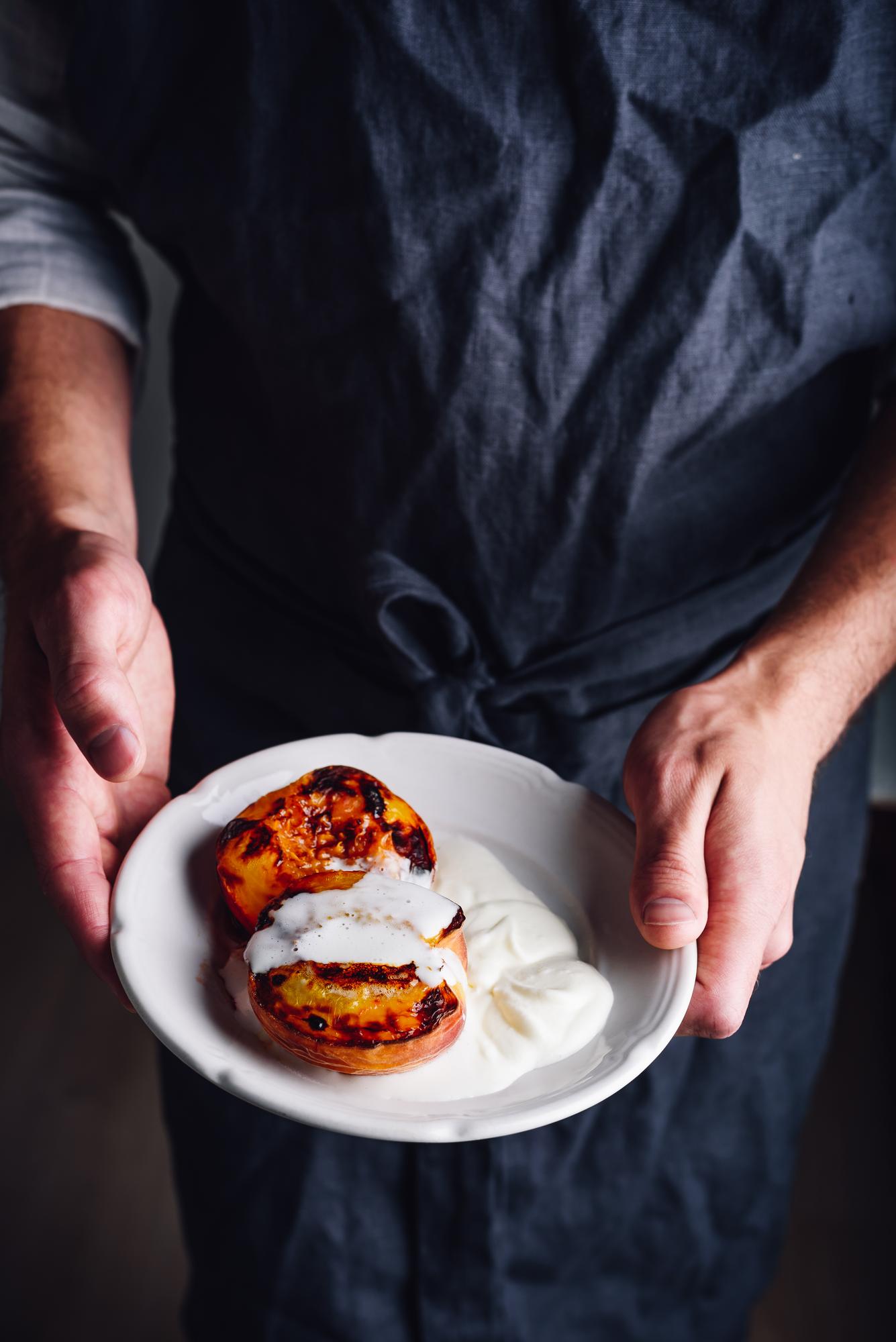 Chef arranging plated dish on wooden table